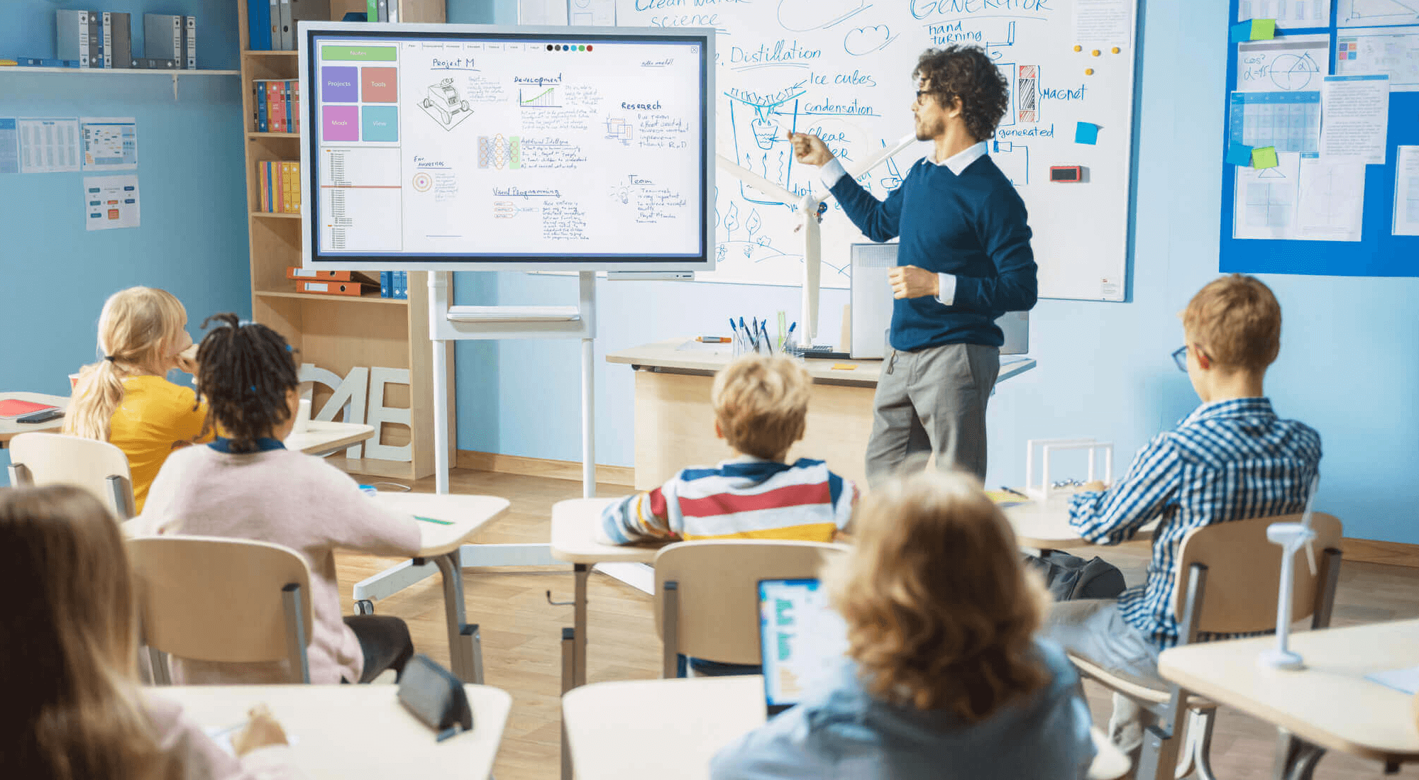 Teacher using an interactive whiteboard to display instructional materials to a classroom